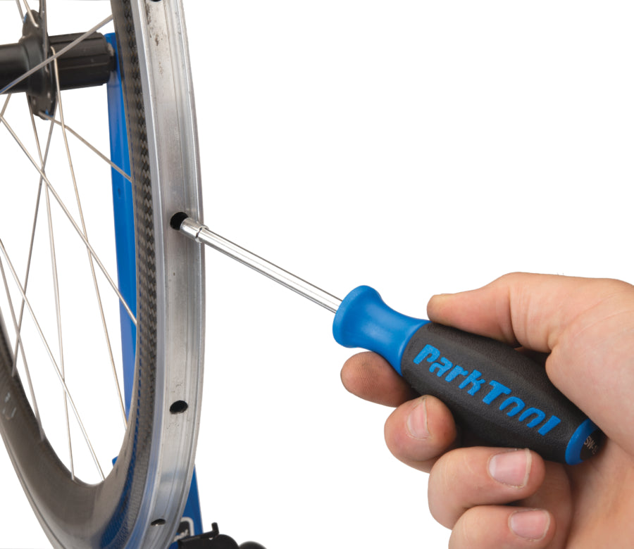 Park Tool SW-19 inséré dans une jante pour atteindre un écrou interne