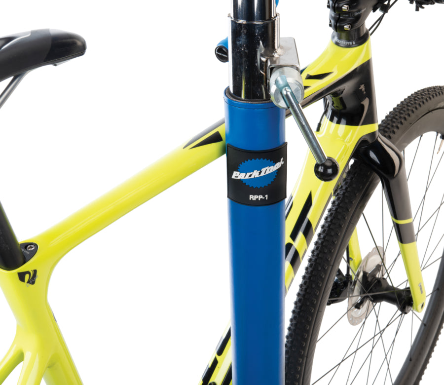 Park Tool RPP-1 avec un vélo appuyé contre le pied d'atelier